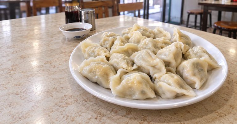 北京の食堂をイメージした、白い皿いっぱいの茹でたてのたまご餃子（AI生成画像）